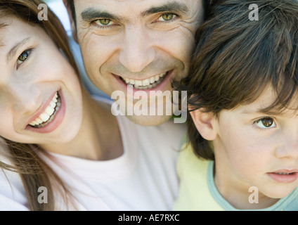 Padre di due figli, ragazzo che guarda lontano, padre e figlia sorridente e guardando la telecamera, ritratto, close-up Foto Stock