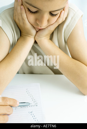 Ragazzo facendo i compiti con l'opera del padre, ritagliato Foto Stock