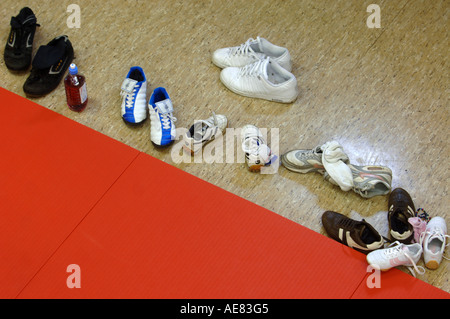 Vista aerea di scarpe per bambini a sinistra accanto al UNA PALESTRA MAT durante l'apprendimento di Judo presso un centro giovanile a Abingdon Oxfordshire UK Foto Stock