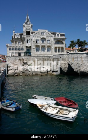 Riga di piccole barche nel porto di Cascais con proprietà lungomare oltre, nei pressi di Lisbona, Portogallo. Foto Stock