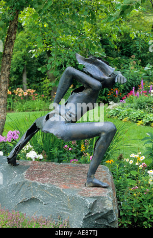 Scultura in bronzo della dea Indù DURGA IN MINNESOTA giardino circondato da piante perenni. La fine dell'estate. Foto Stock