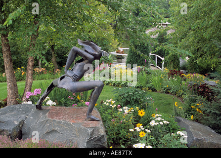 Scultura in bronzo in Minnesota giardino circondato da piante perenni e il fiume betulla. La fine dell'estate. Foto Stock