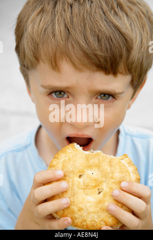 7 ragazzo di mangiare la torta per il pranzo Foto Stock