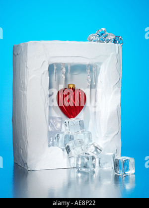 Cuore congelato in una scatola di ghiaccio circondato da ghiaccio a cubetti Foto Stock