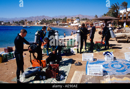 I subacquei prepararsi ad entrare in acqua dalla spiaggia del Faro Dahab Sinai egitto mare rosso Foto Stock