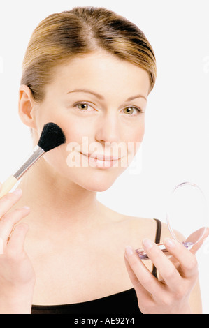 Giovane donna faccia rendendo-up con un pennello, close-up (studio) Foto Stock