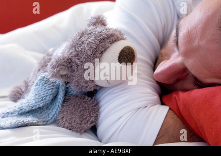 Uomo dorme con un orsacchiotto di peluche, close-up Foto Stock