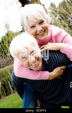Senior portante uomo donna senior per il suo ritorno in giardino Foto Stock