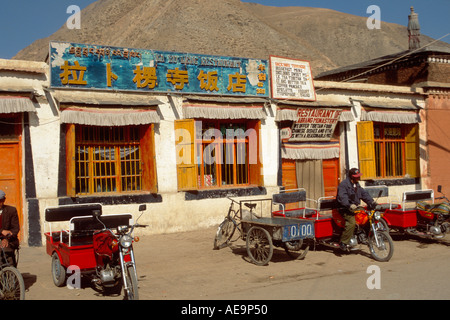 Motociclo taxi stand, al di fuori di un ristorante locale, Xiahe, Gansu, Cina Foto Stock