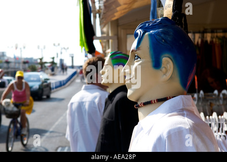 Una chiusura del maschio moderno manichino con sorriso e capelli blu con gli acquirenti sfocati in background Foto Stock
