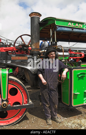 Orgoglioso espositore, in cappello e tute da bocce, di un motore di trazione verde all'annuale fiera di Steam nel villaggio di Chipping, Lancashire, Inghilterra Foto Stock