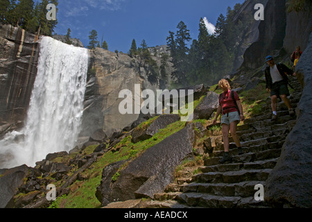 Gli escursionisti sotto primaverile cade che scende 317 durante la primavera run off Yosemite National Park in California Foto Stock