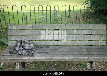 Un scartato shirt su una panchina nel parco Foto Stock