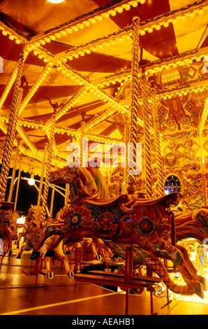 Parco di divertimenti a cavallo sulla giostra di notte con colore arancione da luci artificiali close up dettaglio sharp statico Foto Stock