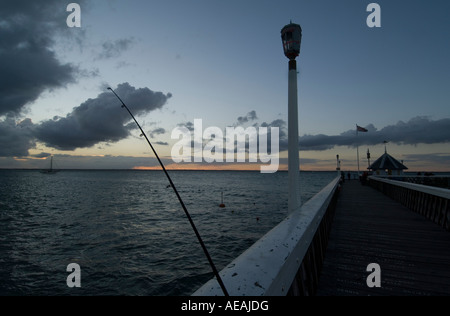 Una tempesta davanti proviene oltre l'Isola di Wight e il Solent in UK-Pesca all'alba per bass e sgombro off il molo Yamouth Isola di Wi Foto Stock