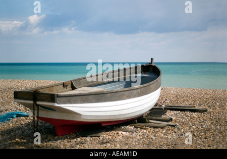 Barca su una spiaggia di ciottoli in una città di vacanze Foto Stock