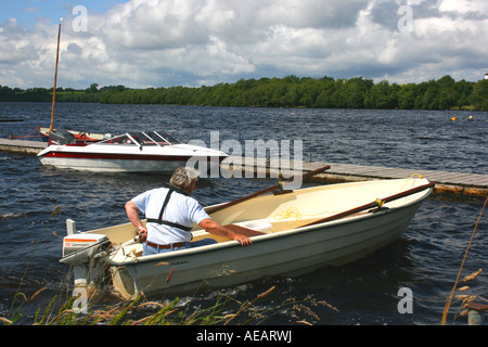 Un uomo su una barca a motore di Muckross Quay in basso a Lough Erne, County Fermanagh, Irlanda del Nord Foto Stock