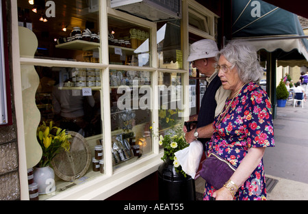 Coppia di anziani guarda nella vetrina di un negozio in Inghilterra a Tetbury Foto Stock