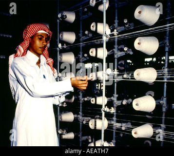 Arabia Saudita uomo che indossa Thobe Ghutra e lavorare in fabbrica Foto Stock