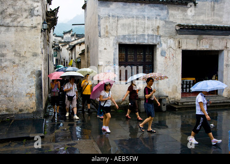 Tour cinese di gruppo sotto la pioggia antico stile Huizhou Villaggio Cinese Xidi Cina Foto Stock