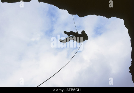 Un alpinista la discesa in corda doppia da un dirupo, Ambleside, Lake District, REGNO UNITO Foto Stock