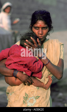 Madre azienda giovane baby come lei cammina per le strade di Delhi India Foto Stock