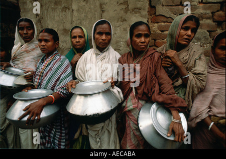 Le donne che trasportano pentole in inizio di mattina di coda di alimentare a Madre Teresa della missione in Calcutta India Foto Stock