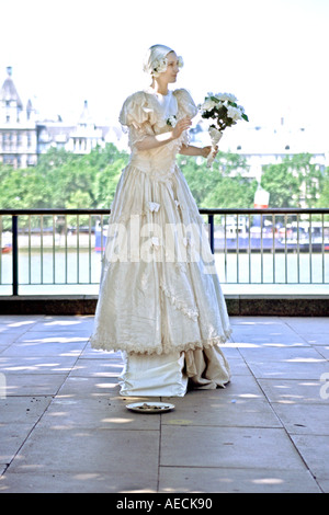 Una donna in costume musicista di strada sulla riva sud del Tamigi a Londra. Foto Stock