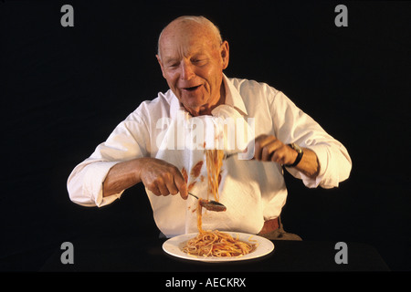 Il vecchio uomo mangiare spaghetti Foto Stock