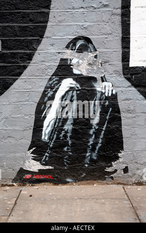 Jef Aerosol incollando su eine atti di vandalismo parete, Shoreditch, Londra Foto Stock