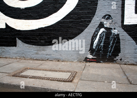 Jef Aerosol incollando su eine atti di vandalismo parete, Shoreditch, Londra Foto Stock