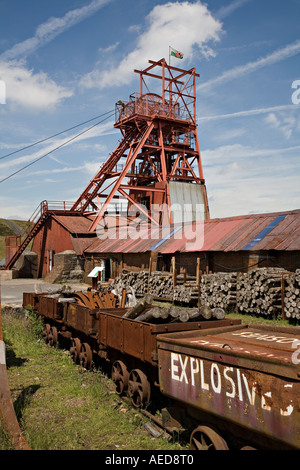 Bandiera gallese volando sopra la marcia di avvolgimento e vagoni ferroviari a Big Pit mining museum Blaenavon Wales UK Foto Stock