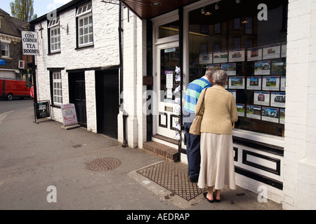 Regno Unito Galles Powys Builth Wells High Street Coppia di mezza età cercando in agenti immobiliari finestra