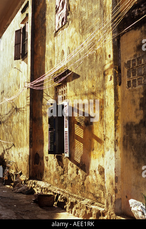 Nel tardo pomeriggio sole che splende sulla weathered decadendo parete di un vecchio edificio, Kampot, Cambogia Foto Stock