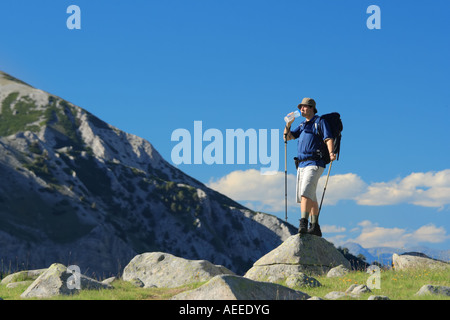 Backpacker in piedi su una roccia nel parco nazionale di Pirin Foto Stock