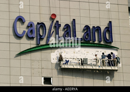 Shanghai Cina lavoratori edili mettendo su accesa lettering compitazione Capitaland sul nuovo edificio Raffles Foto Stock