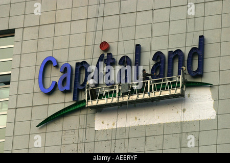 Shanghai Cina lavoratori edili mettendo su accesa lettering compitazione Capitaland sul nuovo edificio Raffles Foto Stock