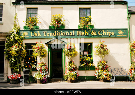 Display floreale al di fuori del USK il tradizionale pesce e patatine il negozio nella città rurale di Usk Monmouthshire South Wales UK Foto Stock