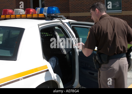 Persona seduta nel retro del cruiser con indirizzamento officer di lui. Soluzione fisiologica dello sceriffo della contea di Office, Nebraska, Stati Uniti d'America. Foto Stock