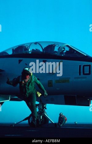 Crewman su un aereo statunitense vettore dà il segnale go per il lancio di aerei da combattimento. USS Carl Vinson. Foto Stock