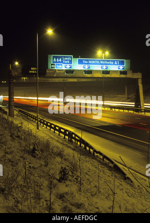 Faro anteriore di percorsi di traffico che viaggia sulla A1 autostrada m1 in inverno di notte nei pressi di Leeds REGNO UNITO Foto Stock