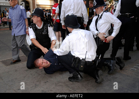 Gli ufficiali di polizia tenere manette e arrestare la giovane tifoso Central London Inghilterra dopo aver perso la Coppa del Mondo 2006. Foto Stock