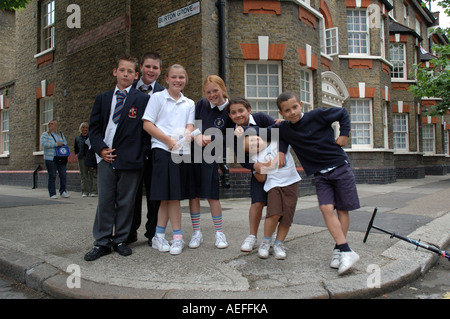 Mescolò età gruppo di bambini in posa di strada sulla strada di casa da scuola Foto Stock