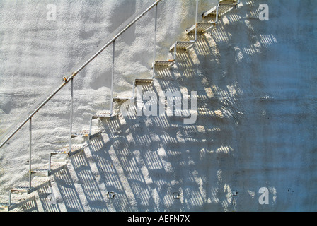 Scale di metallo sul vecchio arrugginito accidentato stucco bianco parete curva, STATI UNITI D'AMERICA Foto Stock