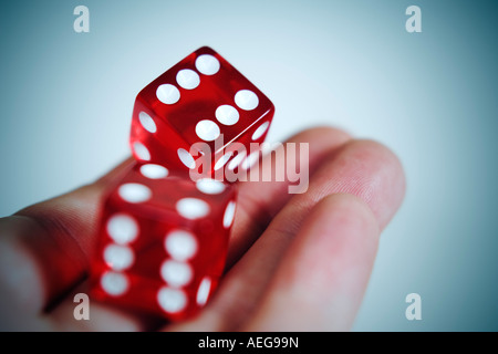 Due rosso ciliegia dice di essere sbalzati fuori dalla mano sinistra che mostra doppio 6' su sfondo bianco Foto Stock