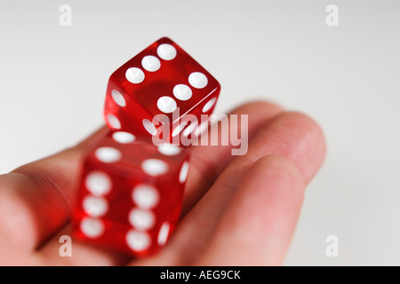 Due rosso ciliegia dice di essere sbalzati fuori dalla mano sinistra che mostra doppio 6' su sfondo bianco Foto Stock