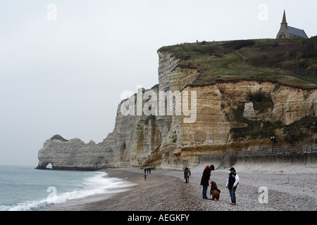 Etretat spiaggia con turisti francesi e Chiesa Normandia Francia Europa Foto Stock
