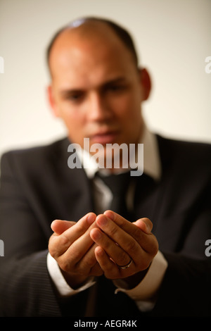 Giovane imprenditore tenendo le mani a tazza. Foto Stock