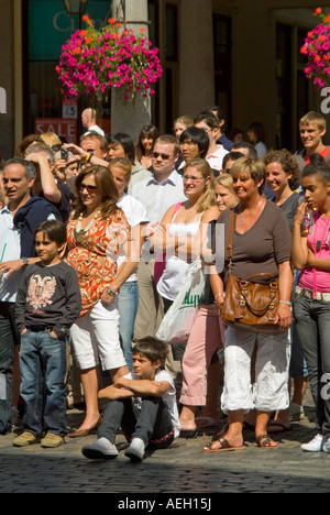 Verticale fino in prossimità di una folla di persone che guardano un esecutore di strada nella piazza di Covent Garden al sole. Foto Stock