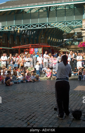 Verticale fino in prossimità di una strada attore divertente la folla della piazza in Covent garden in una giornata di sole Foto Stock